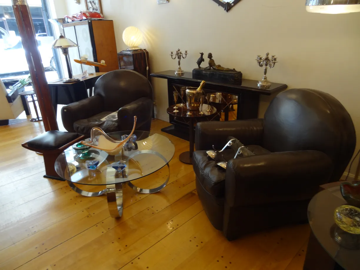 due poltrone antiche in un ambiente decorativo con tavolo e oggetti