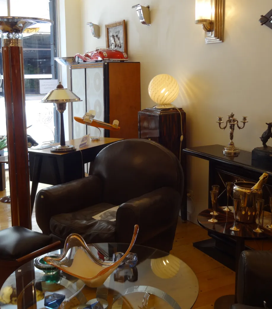 Dos sillones antiguos con curvas suaves y tapizado desgastado en un entorno elegante.