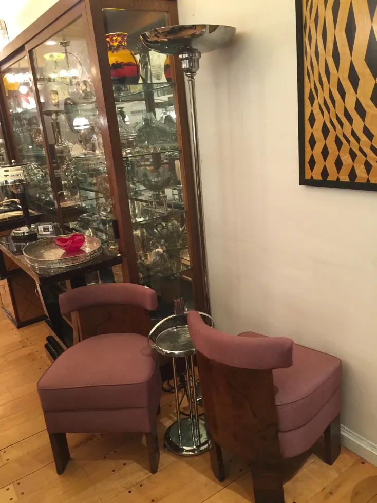 Dos sillones antiguos para restaurar en un ambiente elegante con una lámpara moderna al fondo.