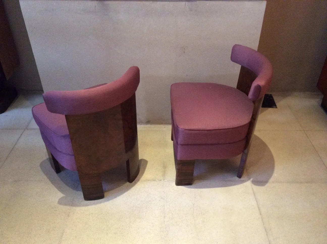 Dos sillones antiguos en un ambiente neutro, tarea de restauración.