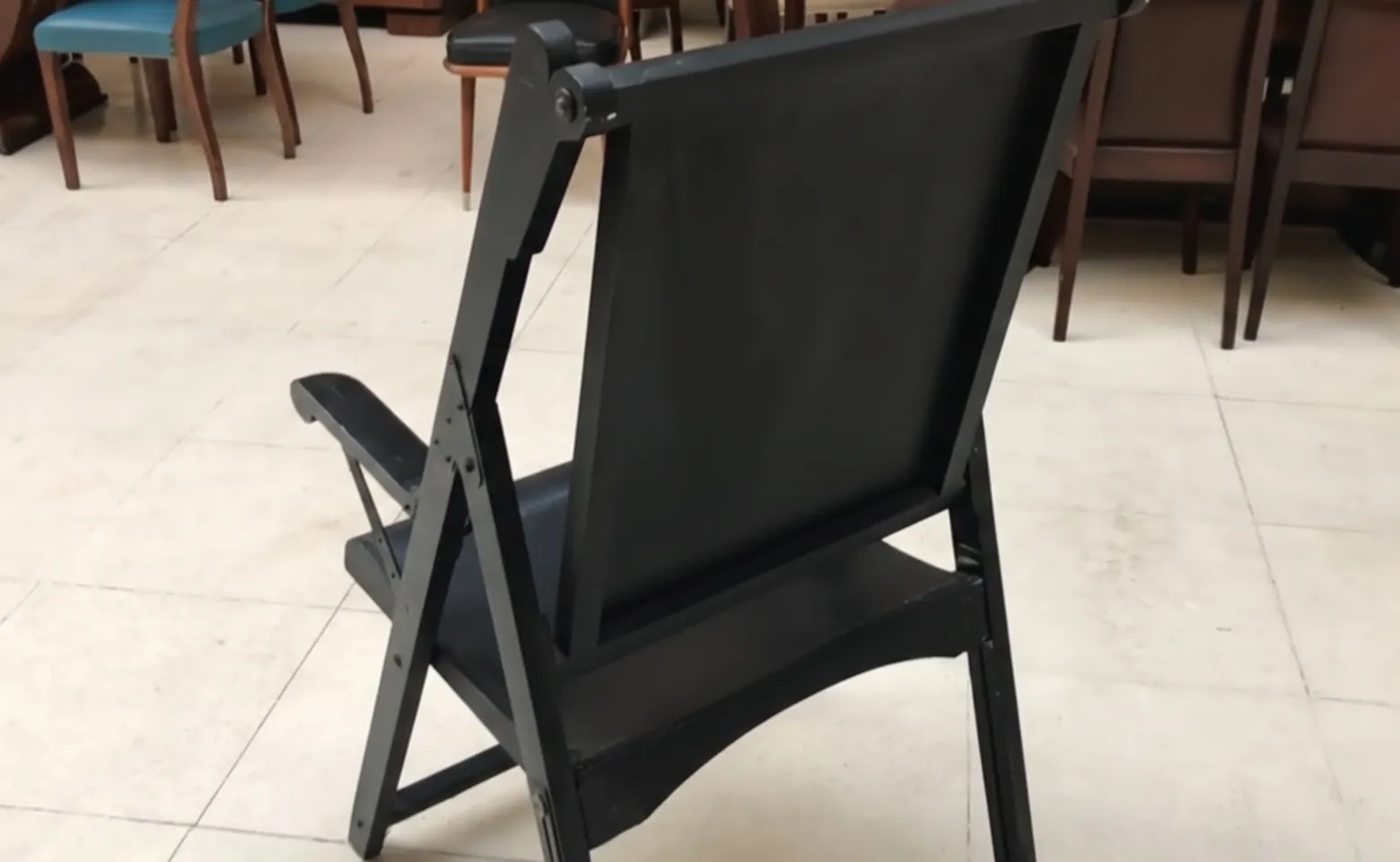 duas poltronas antigas, uma com almofadas, em um ambiente aconchegante.