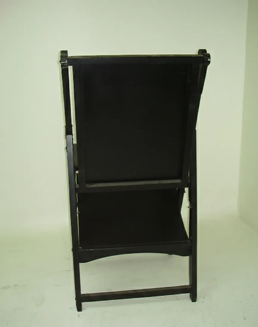 Rear view of two antique armchairs needing restoration.