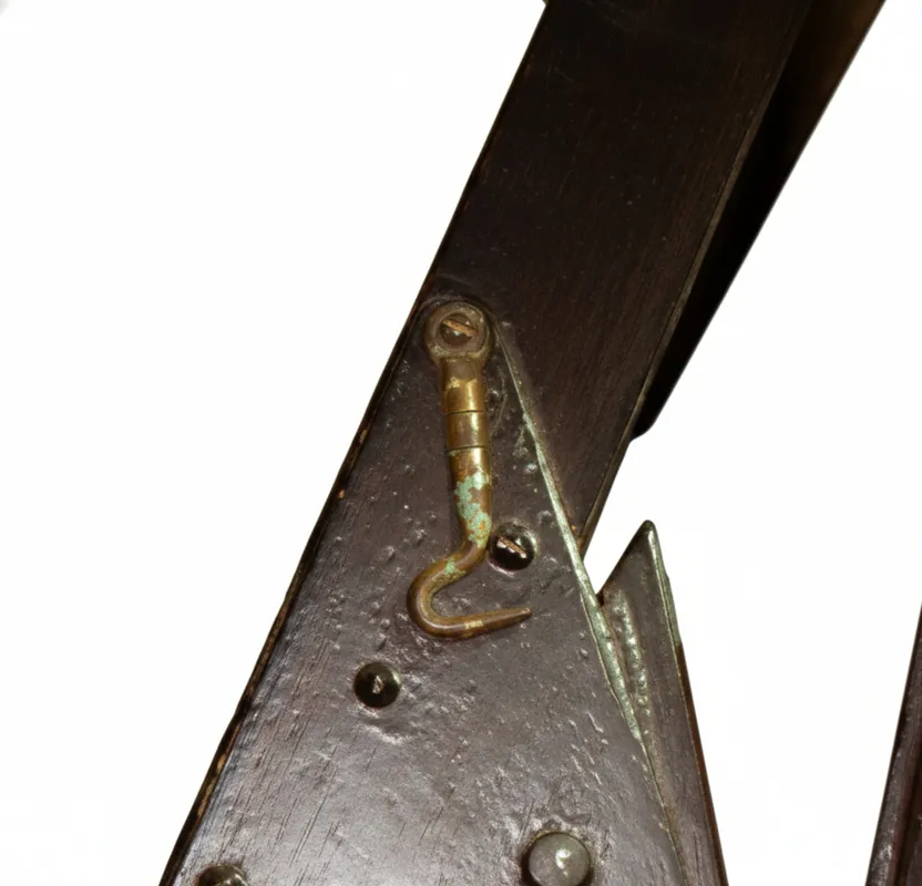 Detail eines alten Mechanismus an Sessel, die restauriert werden müssen, mit rustikalen Texturen und dunkler Holzfarbe.