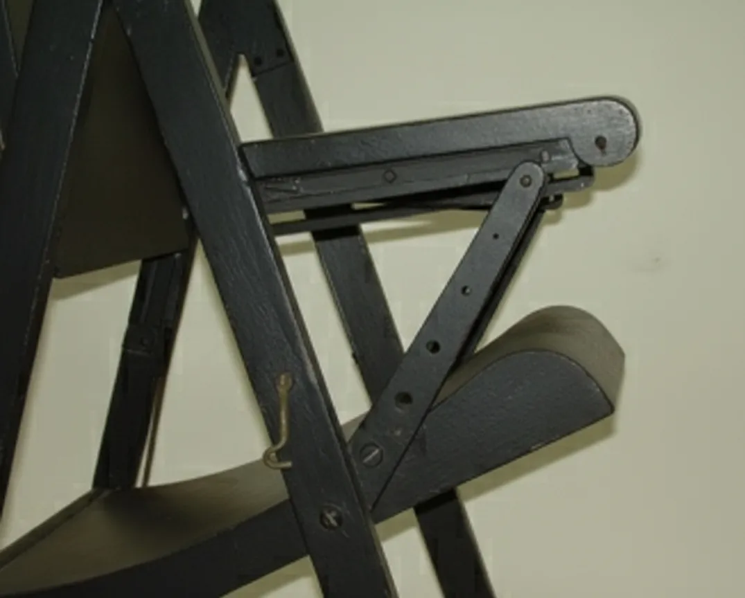 vue latérale de deux fauteuils anciens dans un environnement neutre avec un éclairage doux.