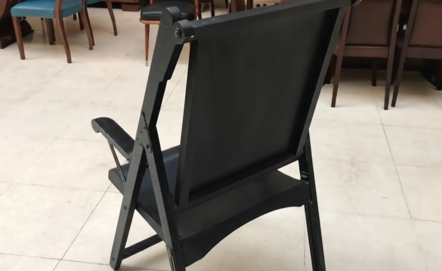 due poltrone antiche in un ambiente di restauro, con sedie sullo sfondo