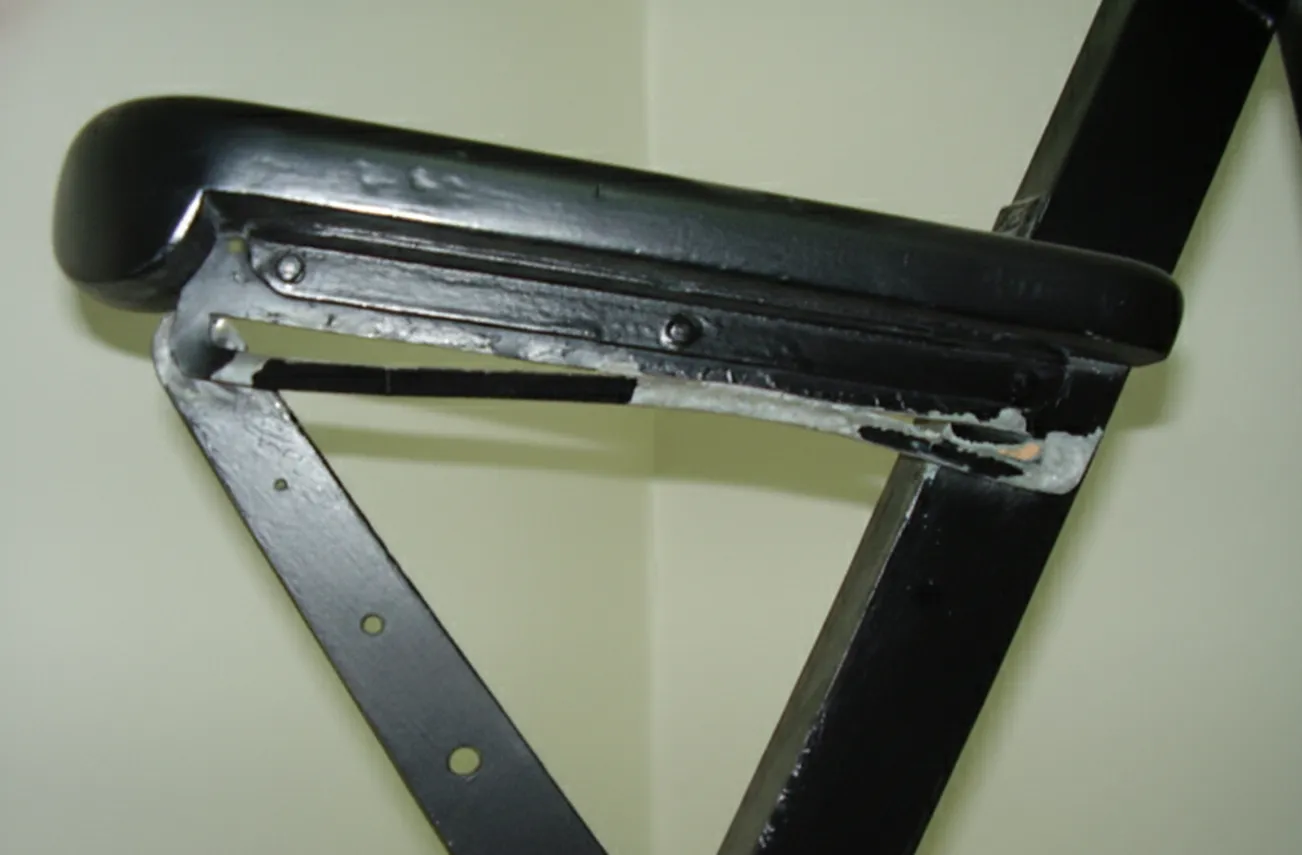 दो पुरातन आर्मचेयर जो पहनने के स्पष्ट संकेतों के साथ, एक तटस्थ सेटिंग में हैं।