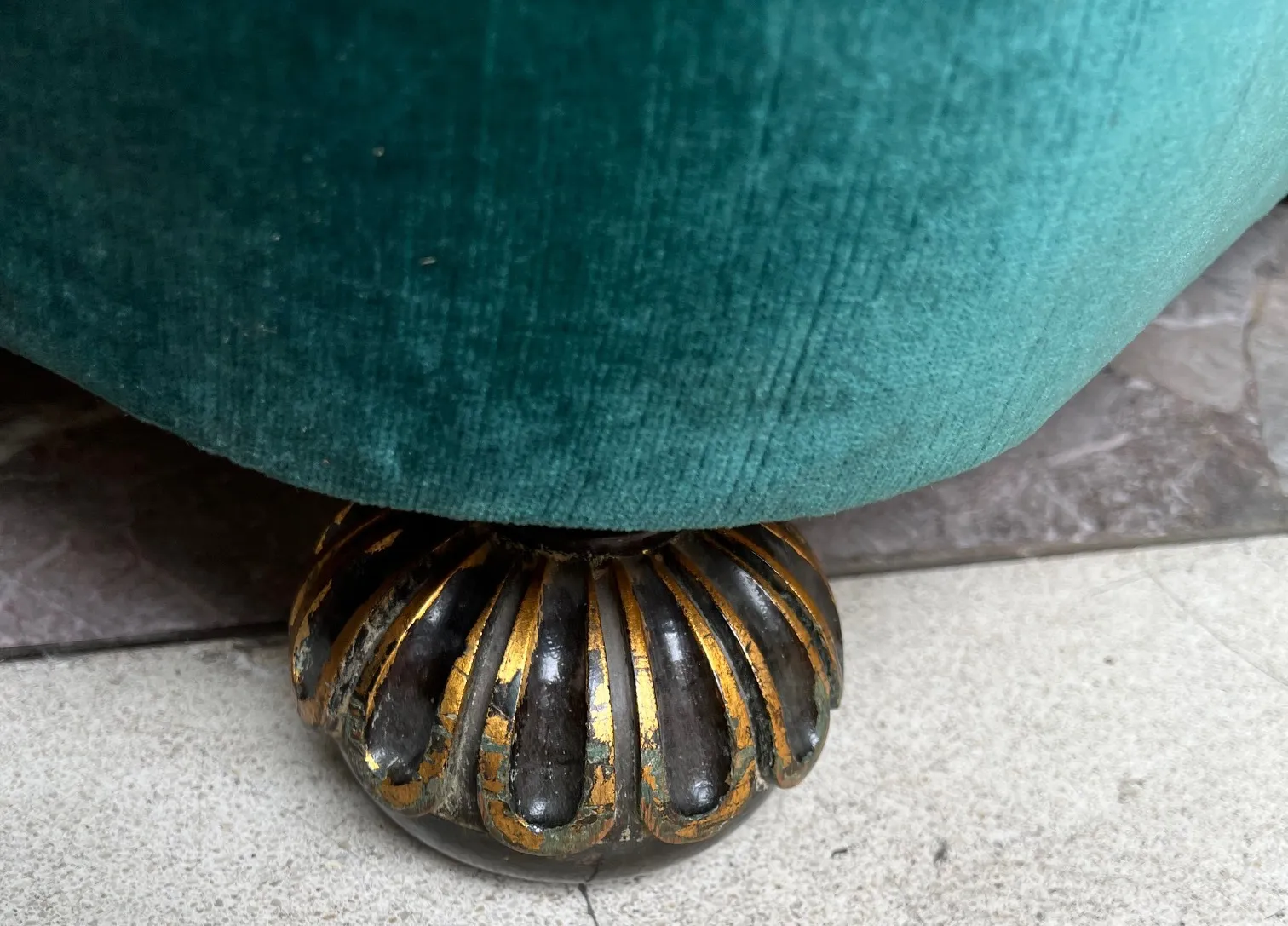 detalhe de uma poltrona antiga com base decorativa