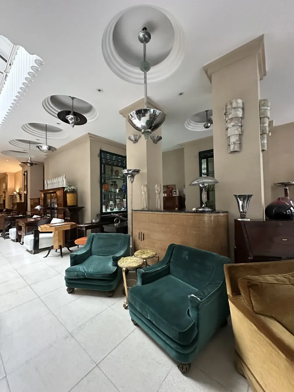 two antique armchairs in a modern room with various furnishings.