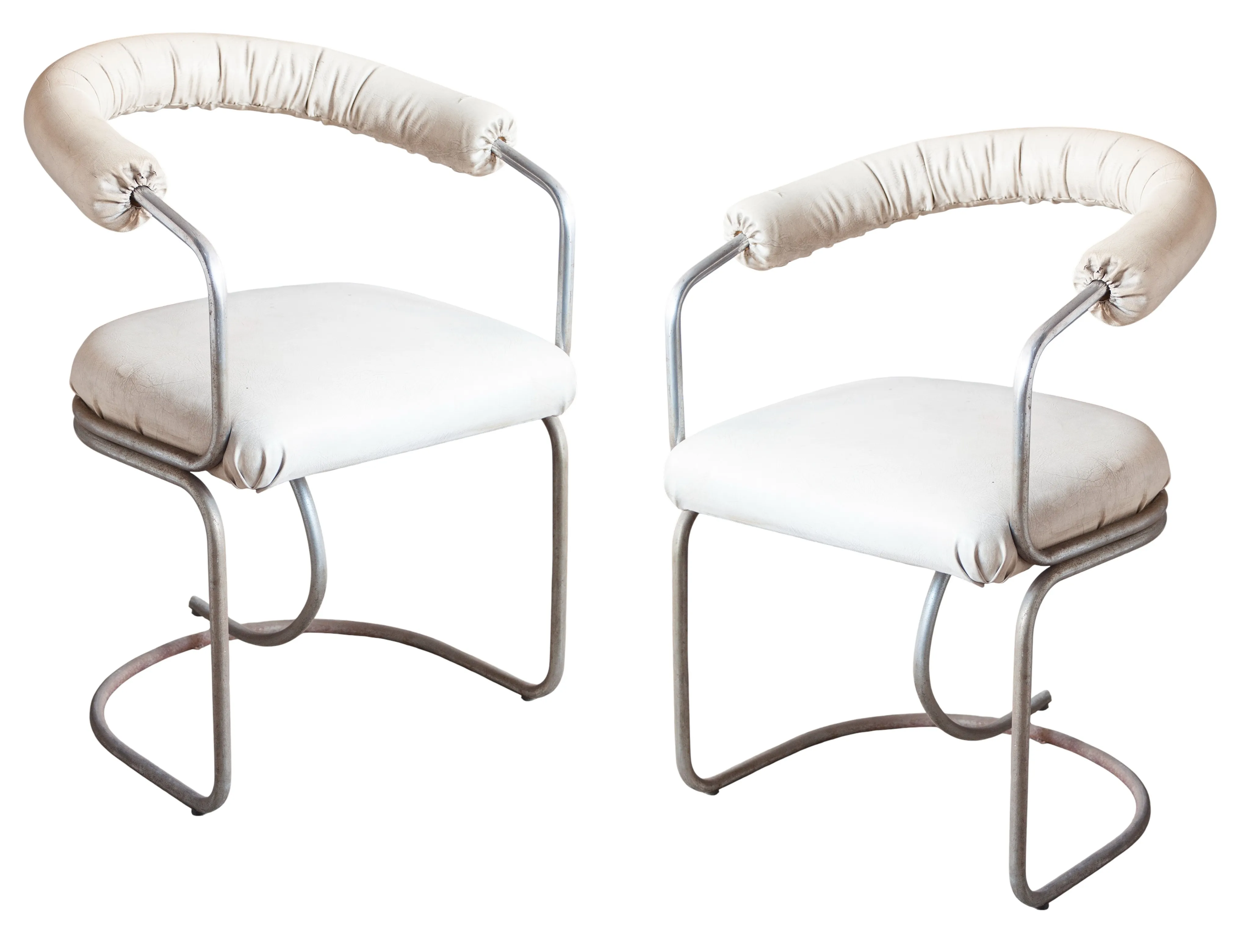 Dos sillones antiguos con brazos, tapizados en blanco, en un ambiente neutral.