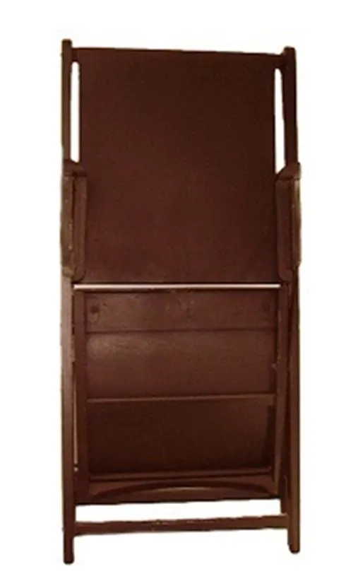 Back view of 2 antique armchairs, one in dark colors, in a rustic setting.