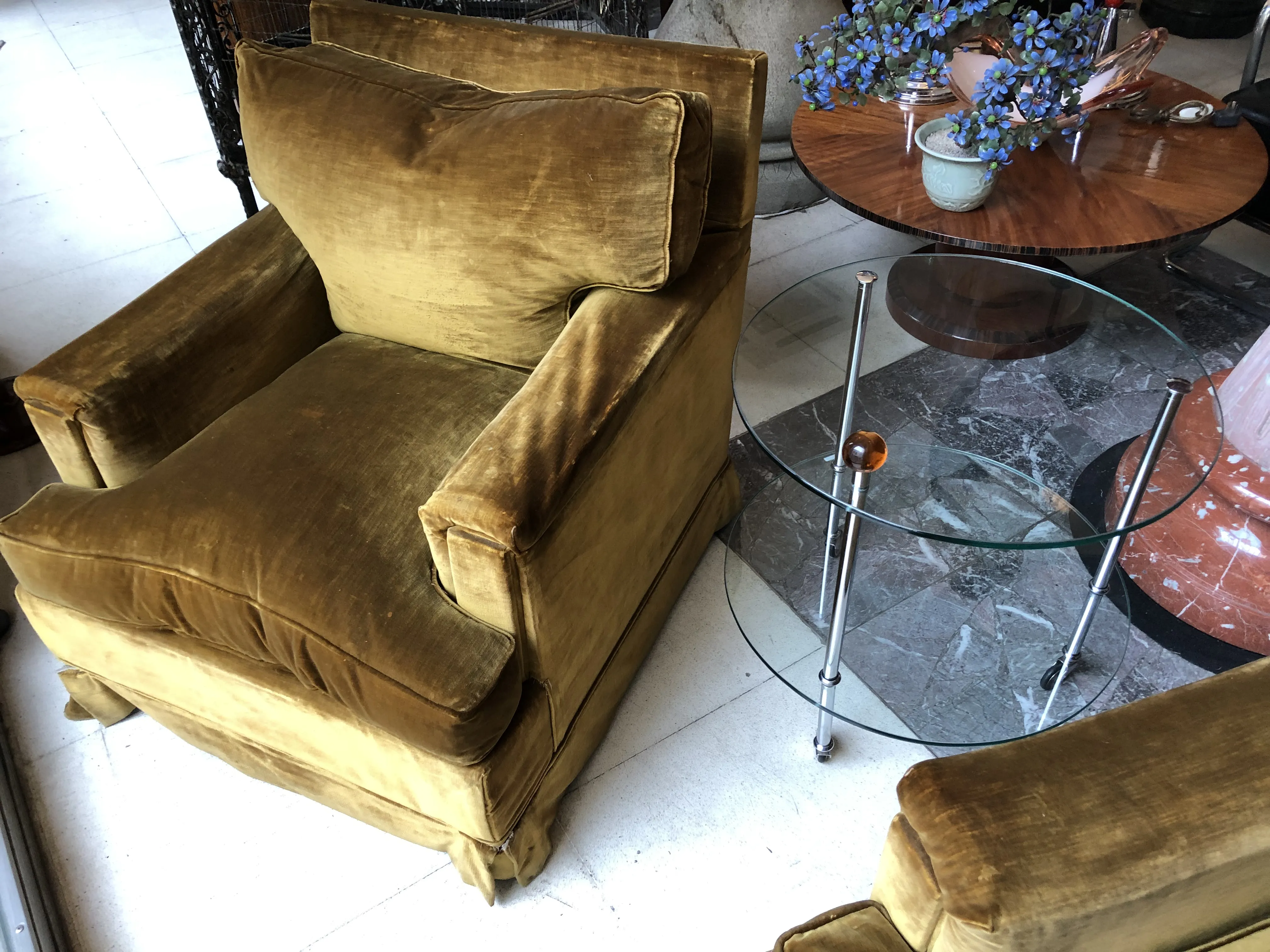 Vue détaillée de deux fauteuils anciens à restaurer dans un cadre confortable avec une table en verre.