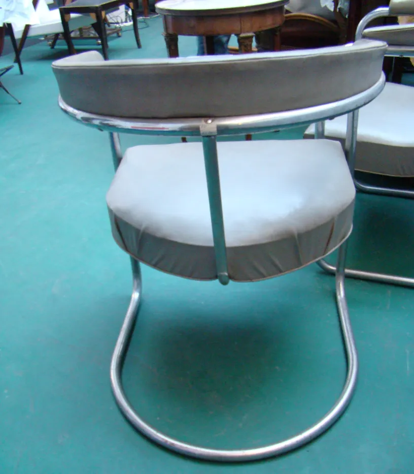 Vue de derrière de deux fauteuils anciens à restaurer, dans un environnement d'antiquités.