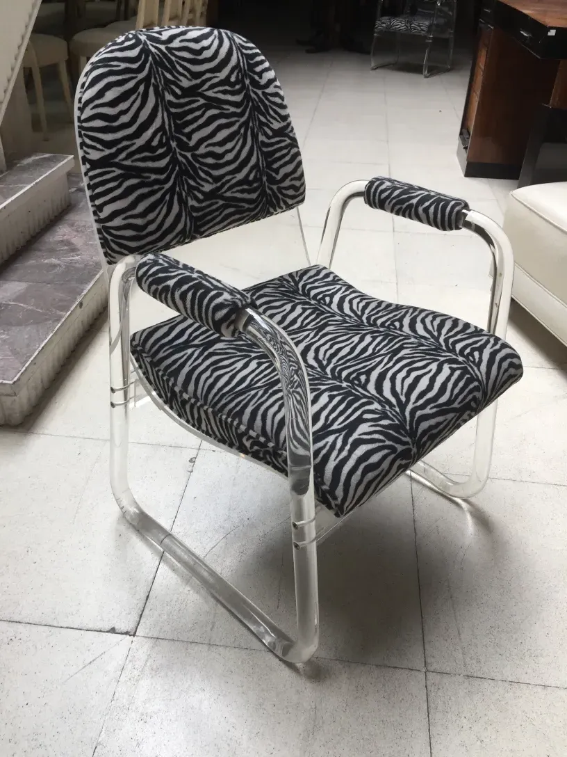 Dos sillones antiguos con estampado de cebra, en un ambiente acogedor.