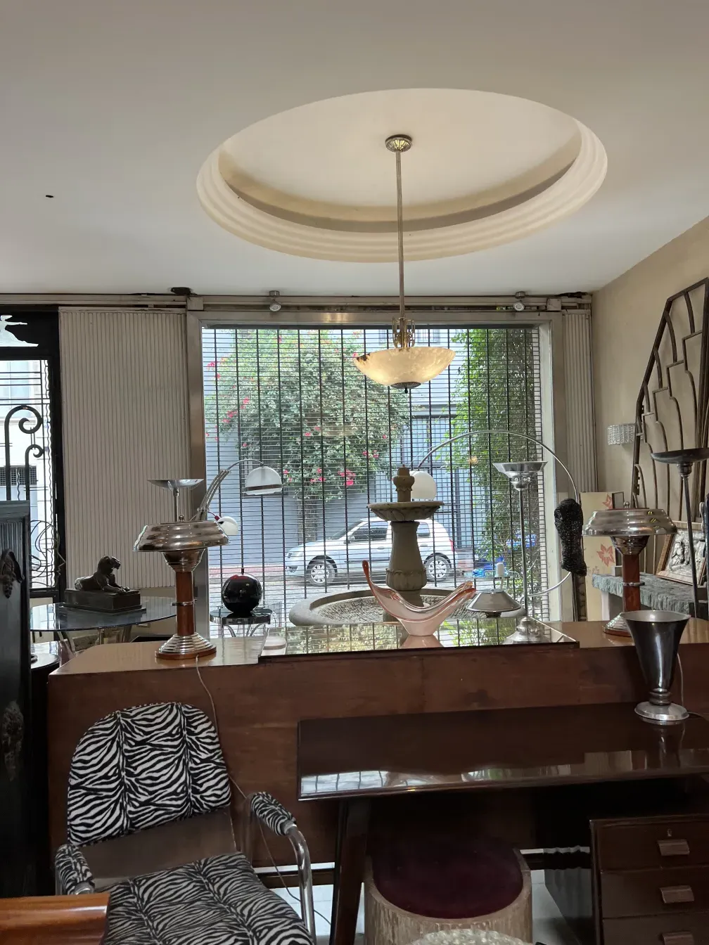 two antique armchairs in an elegant setting with lamp and table.