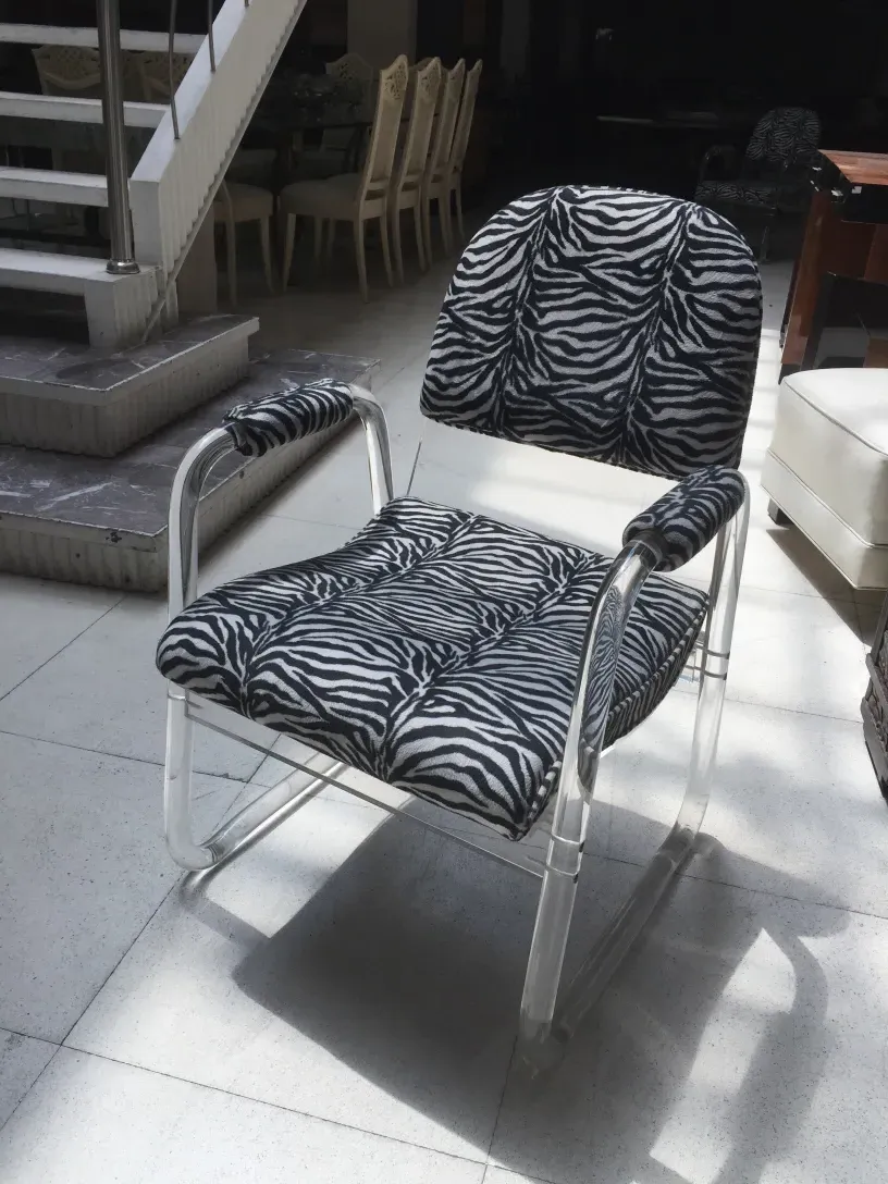 anciens 2 fauteuils en forme de U avec imprimé zèbre dans une pièce.