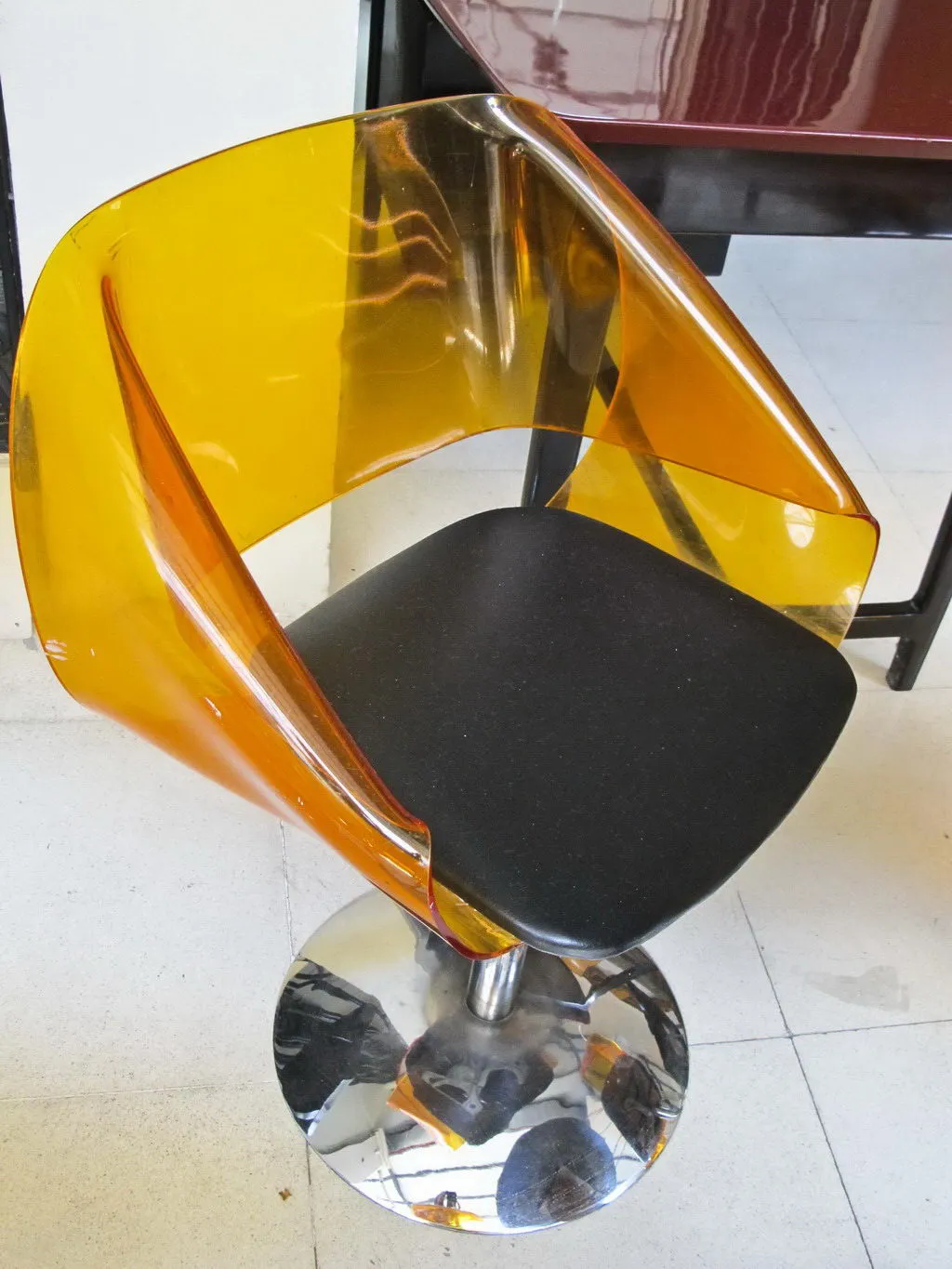 Cuatro sillas antiguas de diseño con respaldo translúcido, color amarillo, en un ambiente moderno.