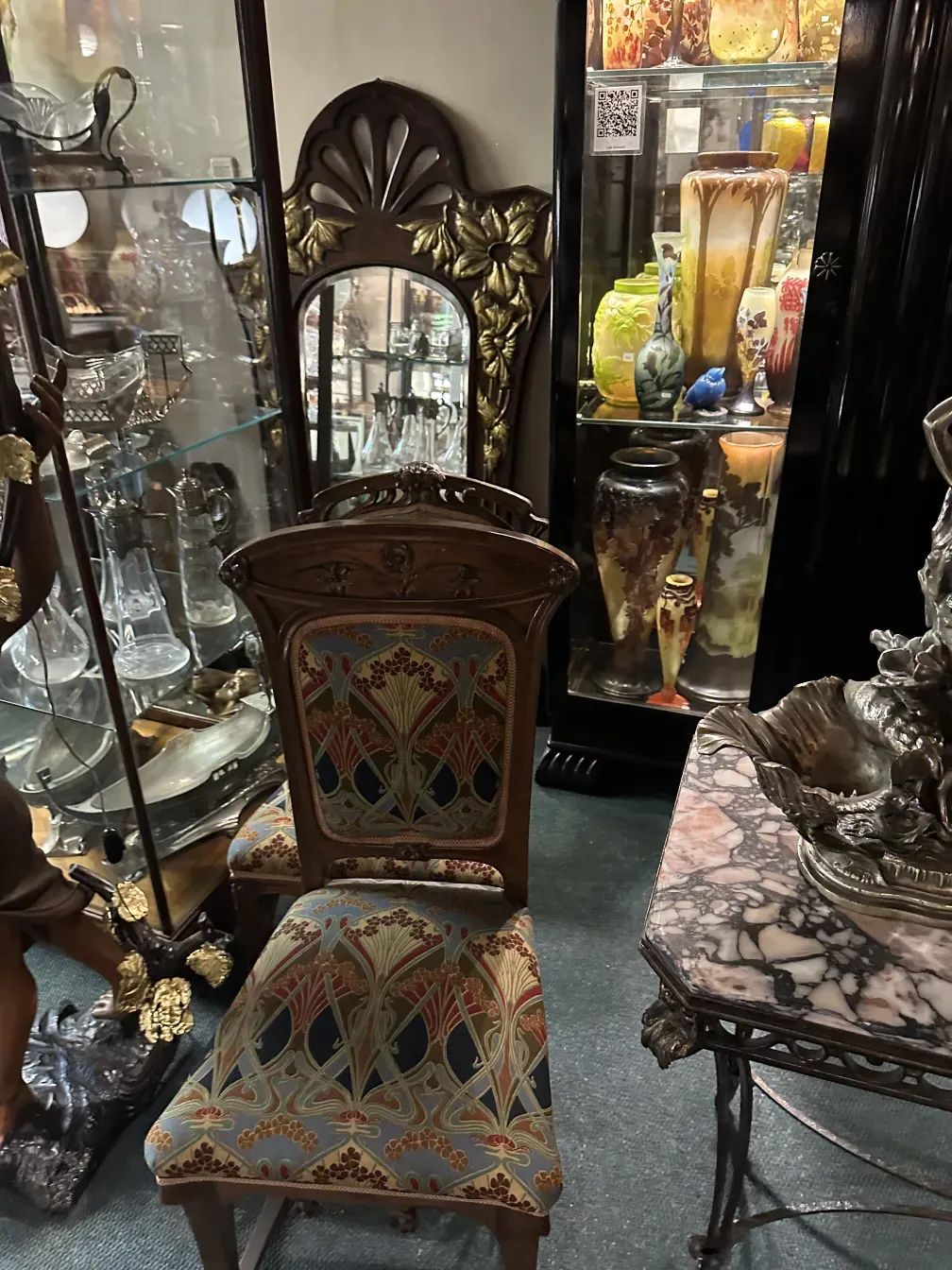 cadeira antiga de estilo Art Nouveau com detalhes coloridos em um ambiente decorativo