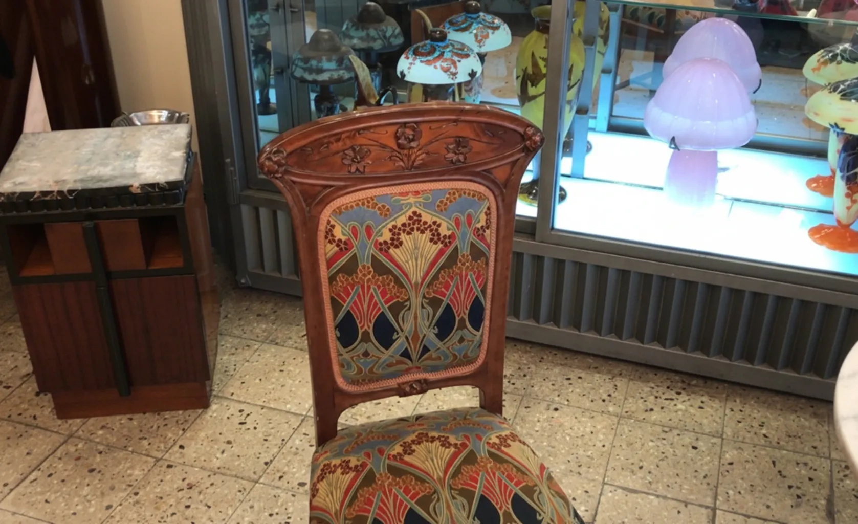 sedia antica con design art nouveau, colorata e decorativa, in un ambiente di antiquariato