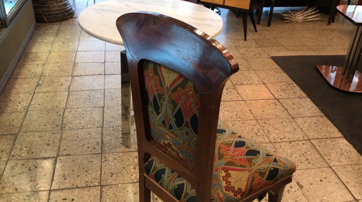 Silla antigua con respaldo curvado y tela colorida