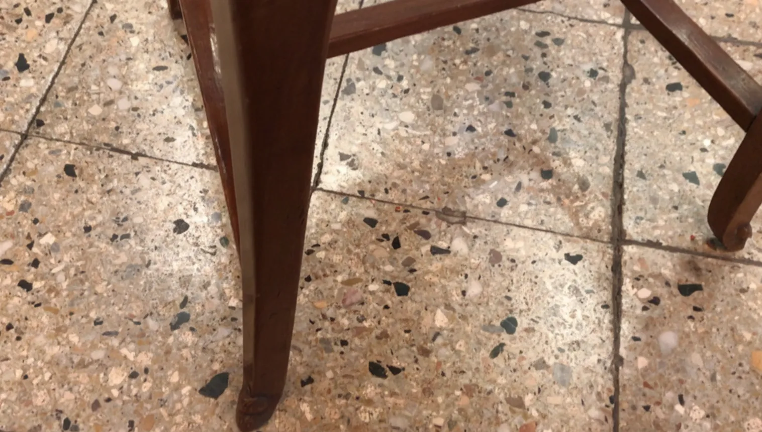 dettaglio di una sedia antica art nouveau con gambe fini in un ambiente neutro