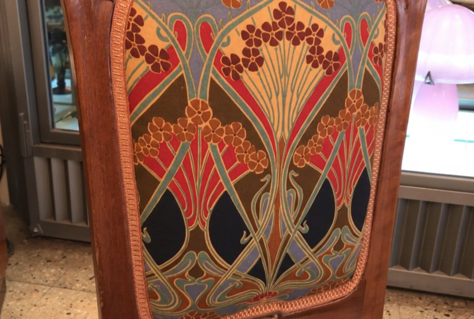 Antique chair in Art Nouveau style with colorful floral design.