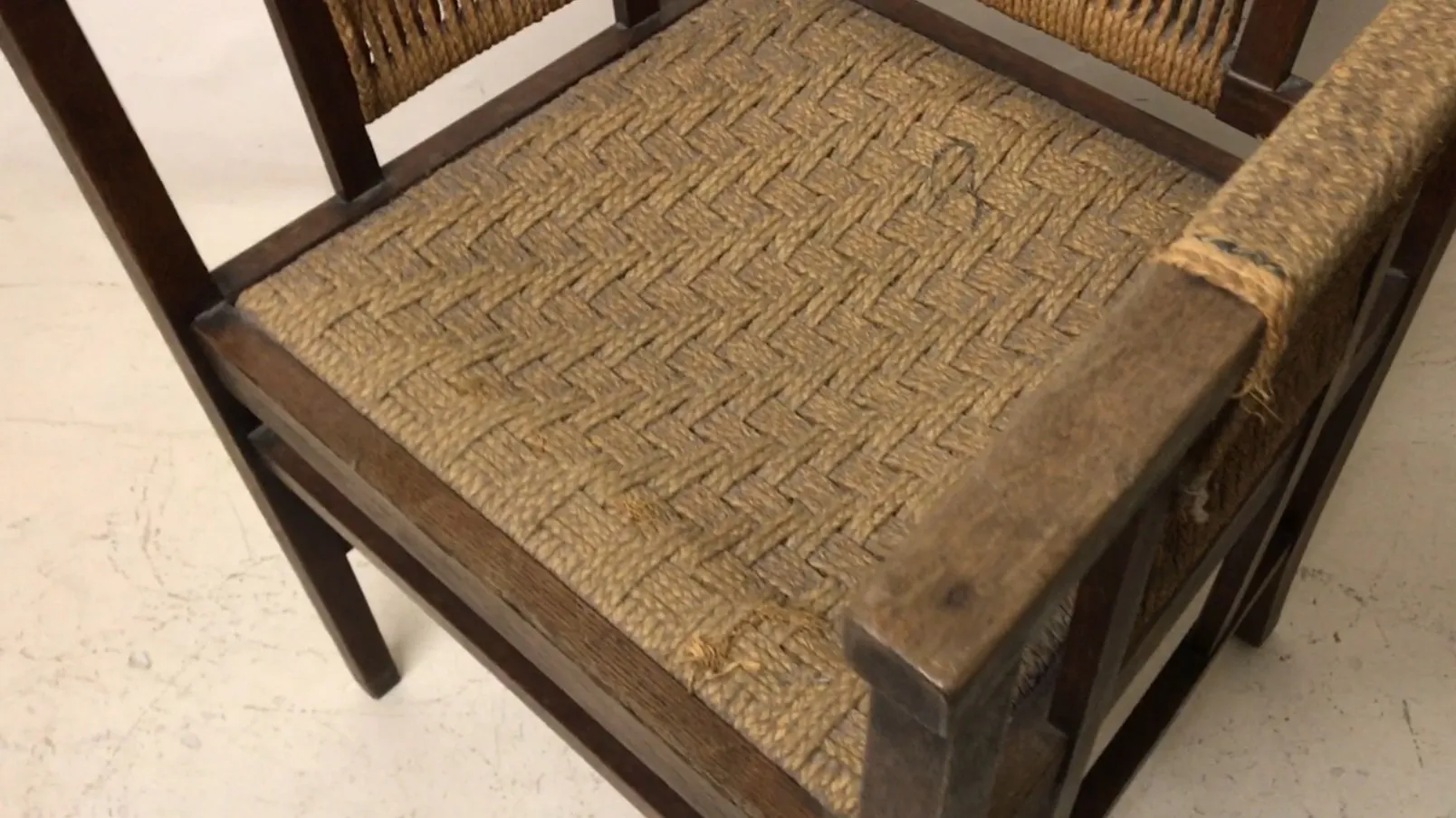 Antique desk chair with woven seat in a bright setting.