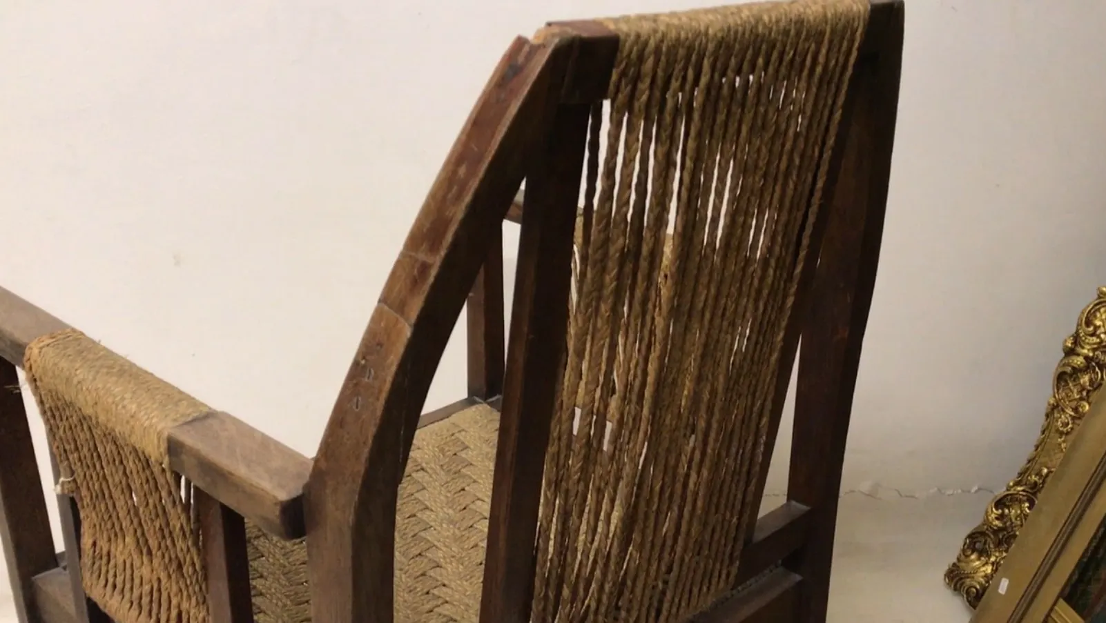 antique desk chair with rope backrest in neutral setting