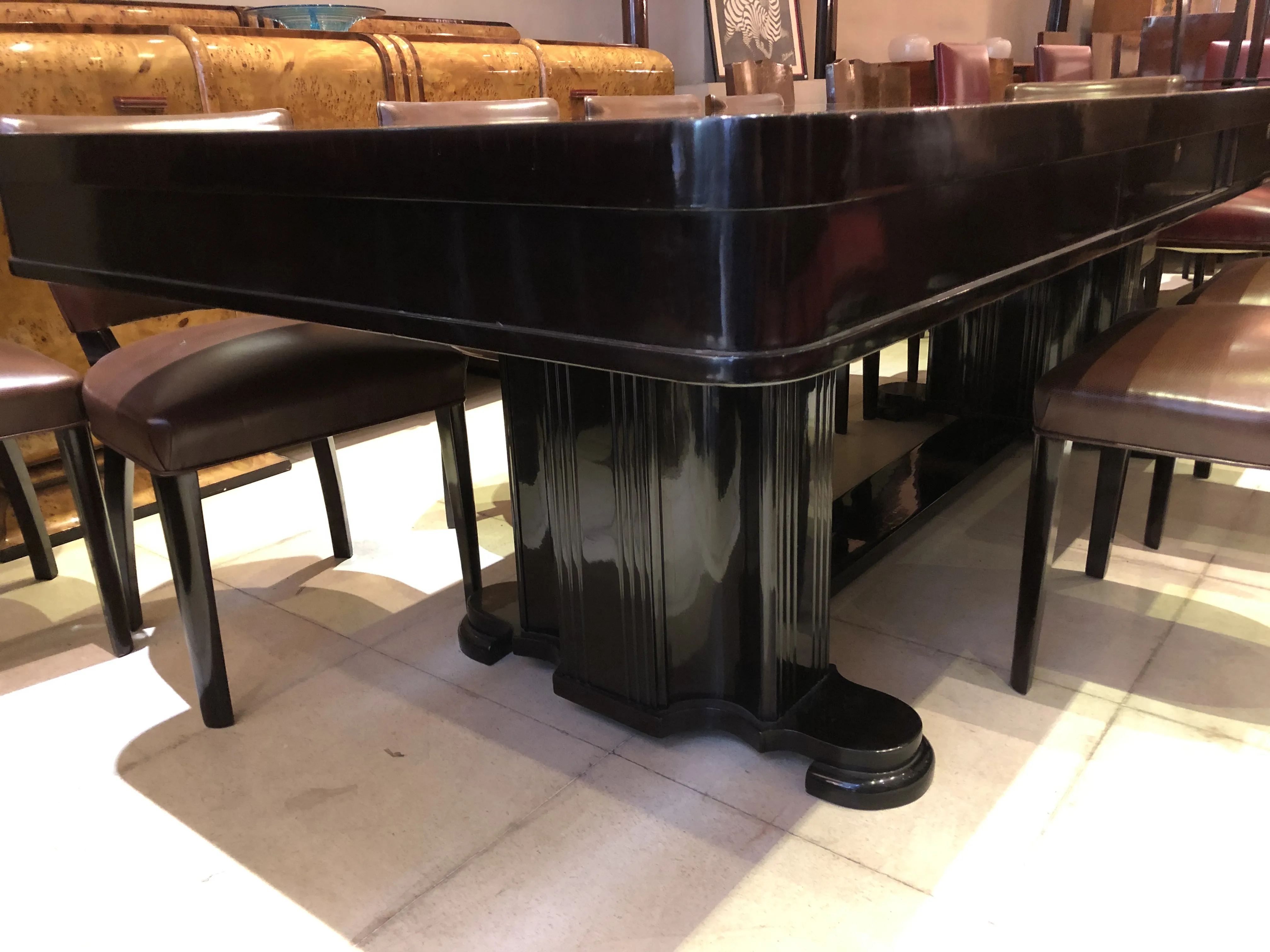 Mesa de jantar antiga para 10 pessoas, elegante e robusta, cercada por cadeiras.