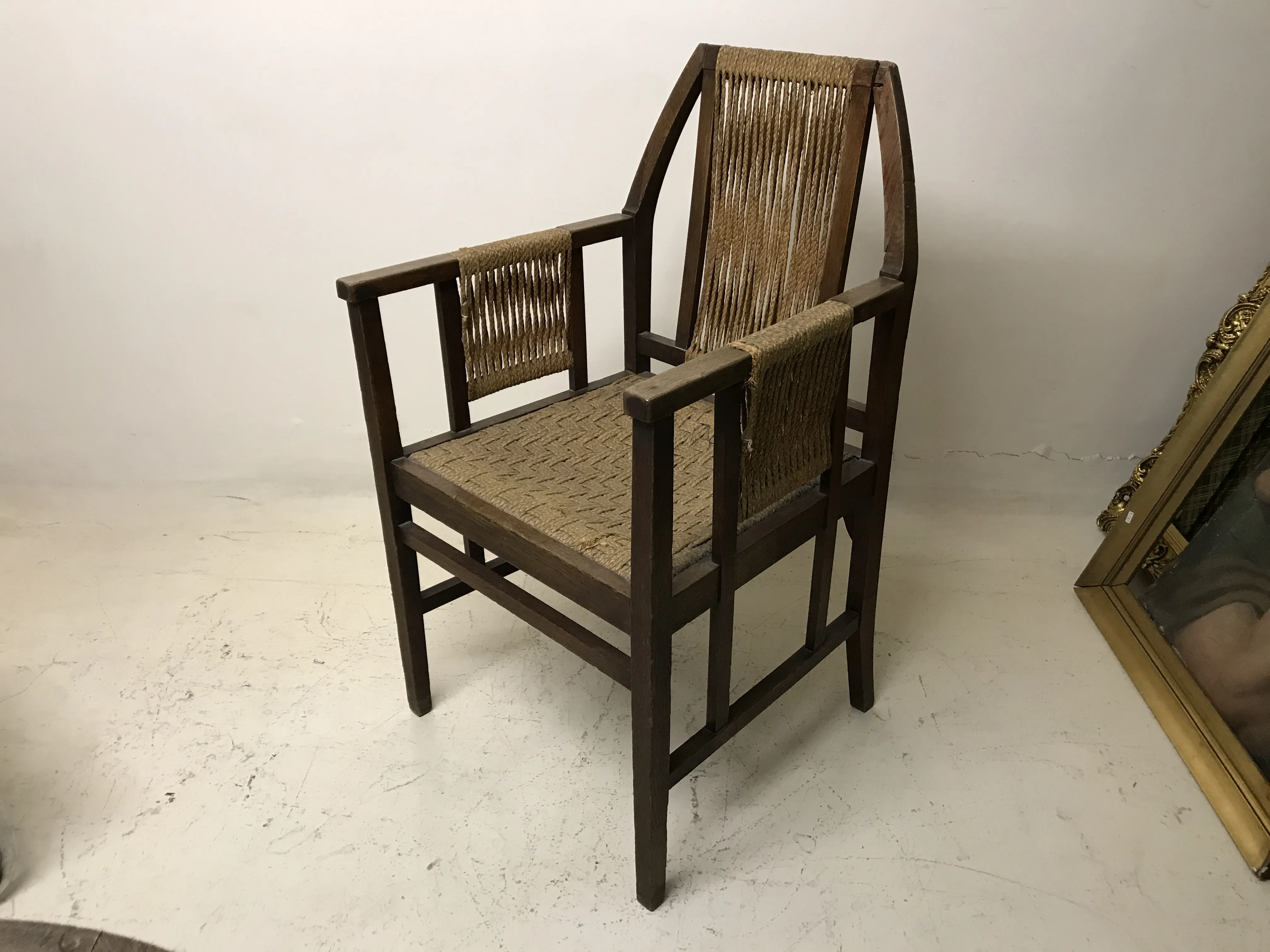 Sillón de escritorio antiguo con diseño de Edward Wormley. Color marrón. Sillas de oficina en el fondo.