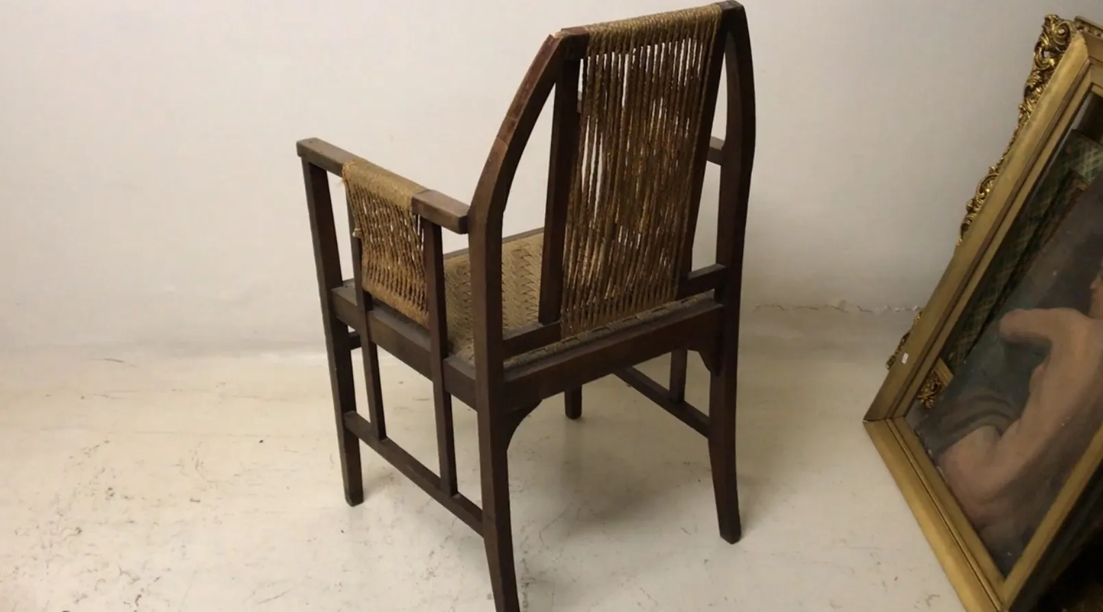 Sillón de escritorio antiguo con respaldo alto y brazos, en un ambiente claro.