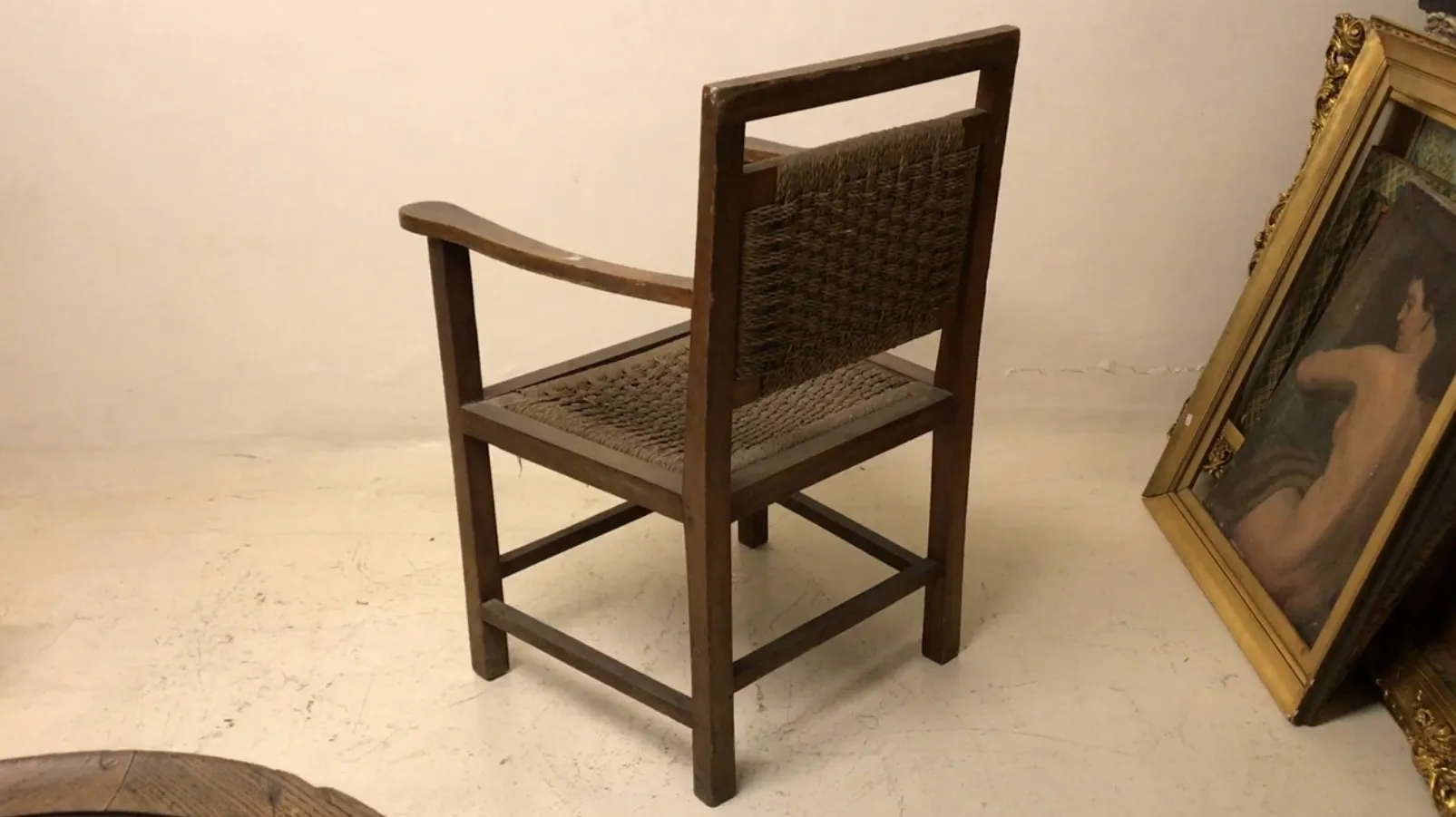 antique armchair with arms, light background, simple setting.