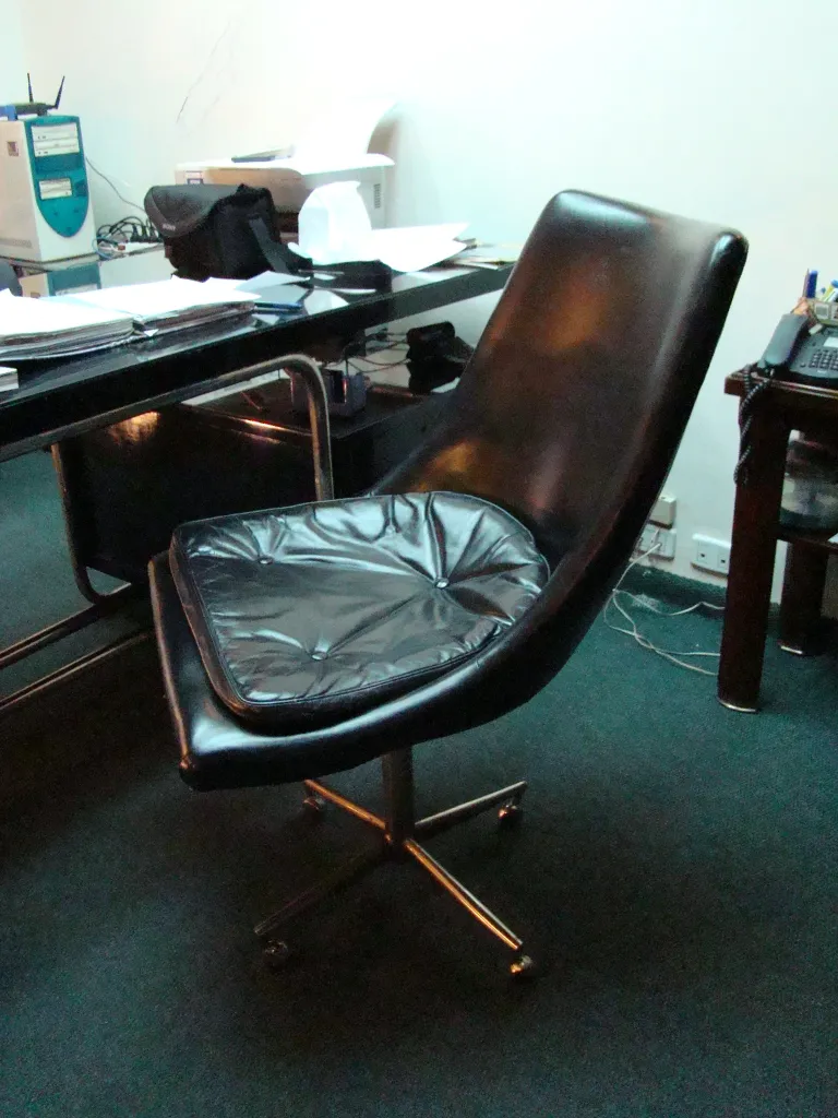 Cadeiras de escritório antigas com um design clássico em um ambiente profissional.