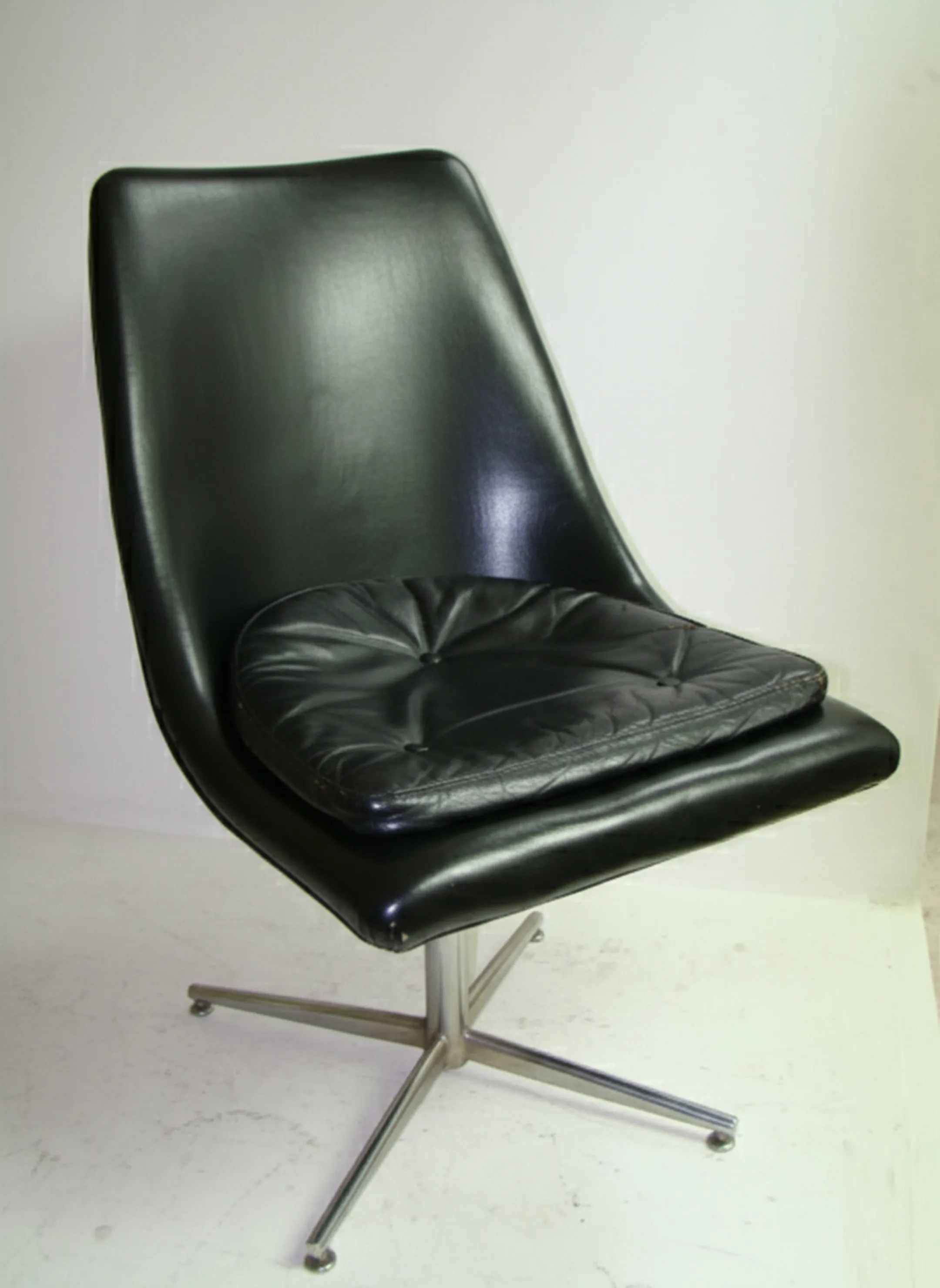 Vue latérale de deux chaises de bureau anciennes, l'une avec coussin