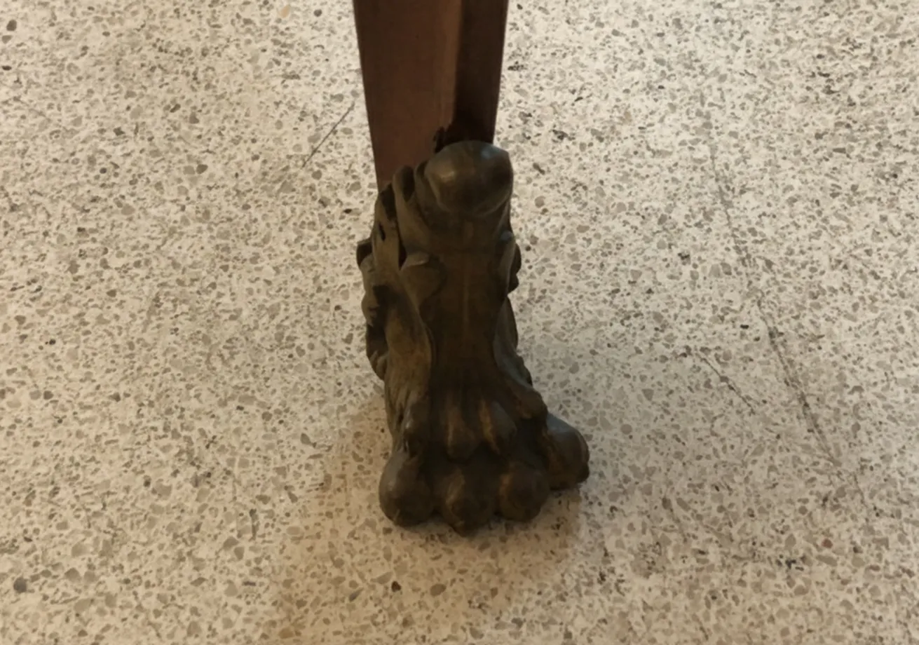 Dettaglio delle gambe di 2 sedie antiche, con design ornamentale in un ambiente chiaro.