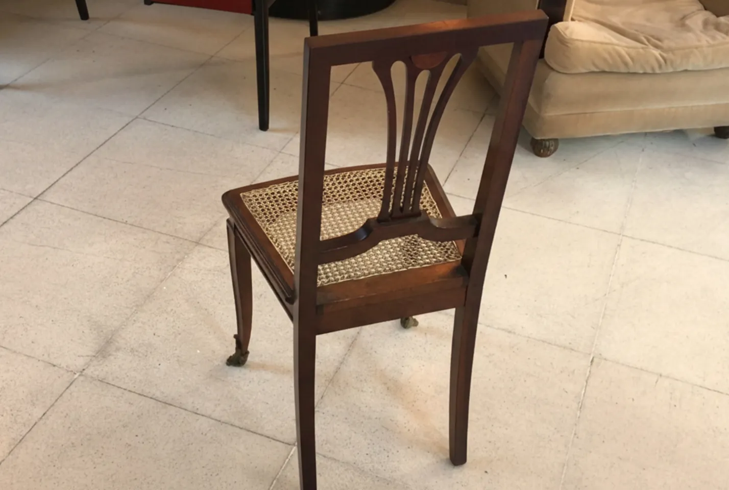 Back view of 2 antique chairs in a modern setting.
