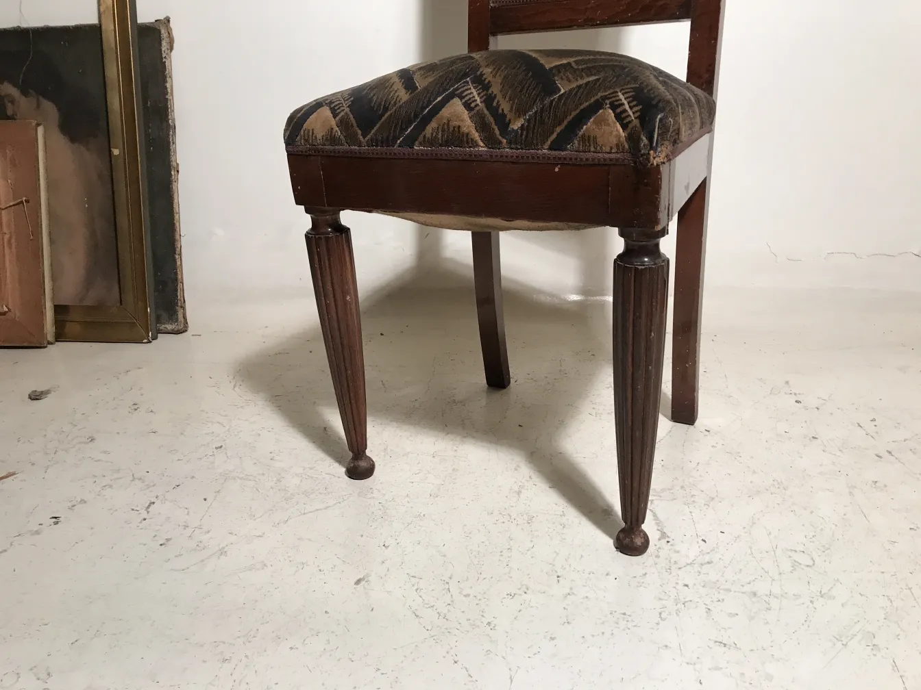 Duas cadeiras antigas com pernas torneadas e tecido decorativo.