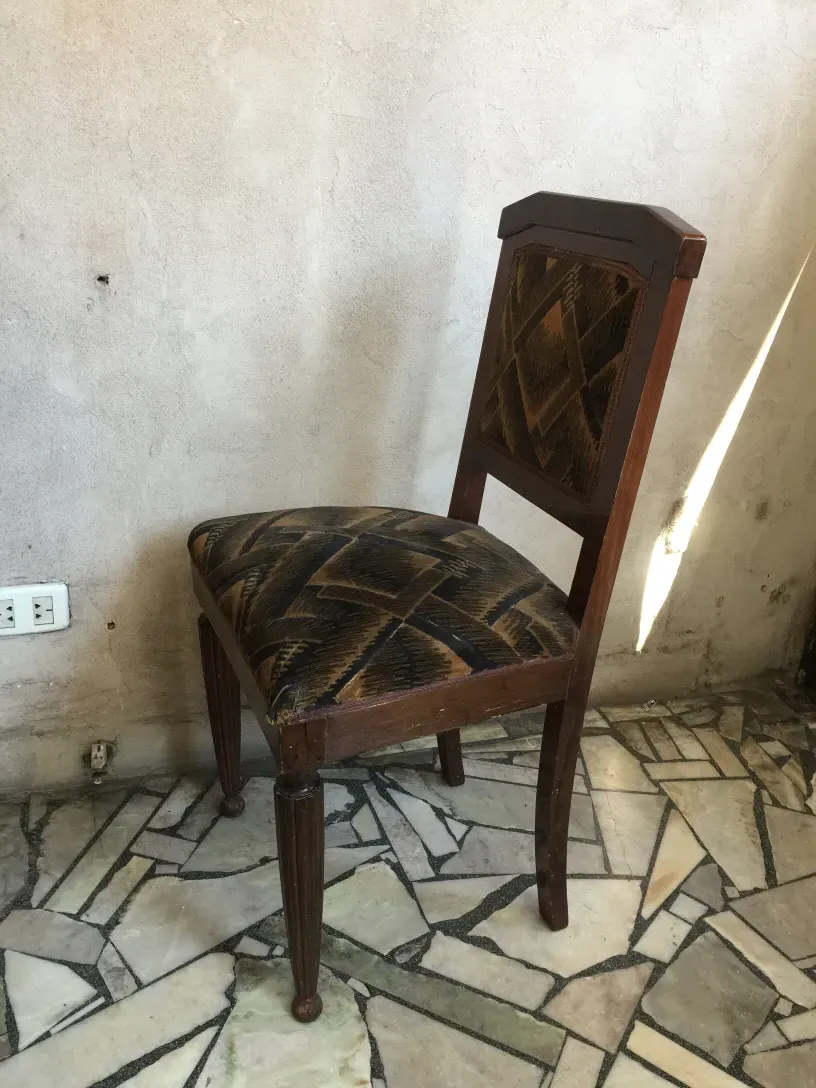Side view of two antique chairs with interesting design in a simple environment.