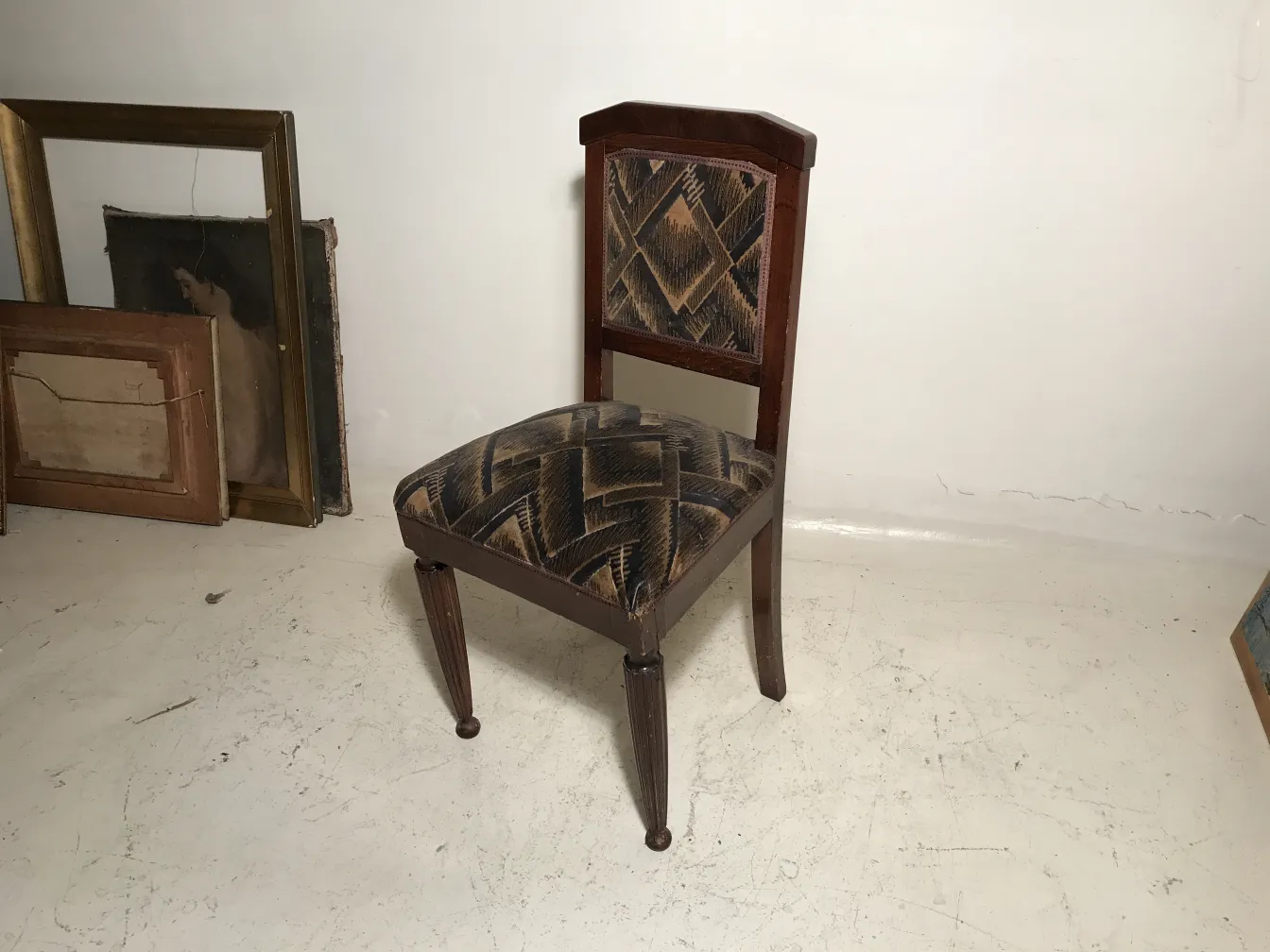 deux chaises anciennes dans un environnement avec des cadres et de l'art