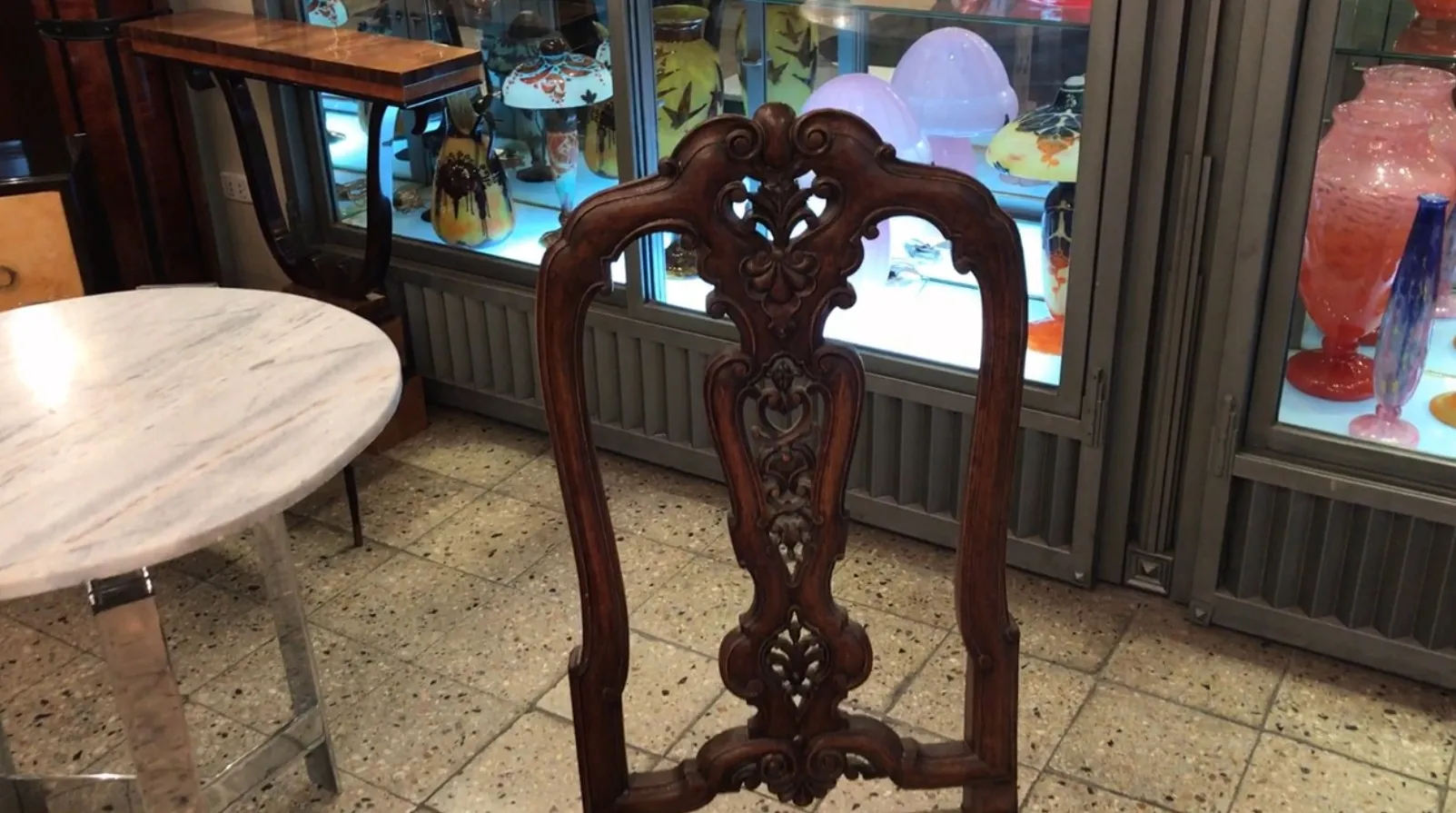 2 antique chairs with ornate details for restoration in an antiques setting.
