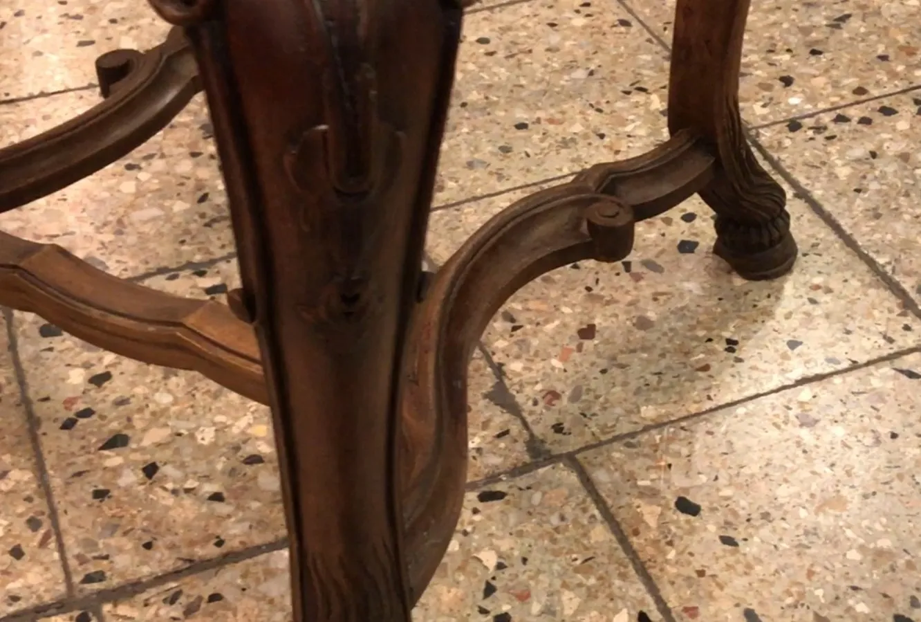 duas cadeiras antigas com detalhes decorativos em um ambiente simples.