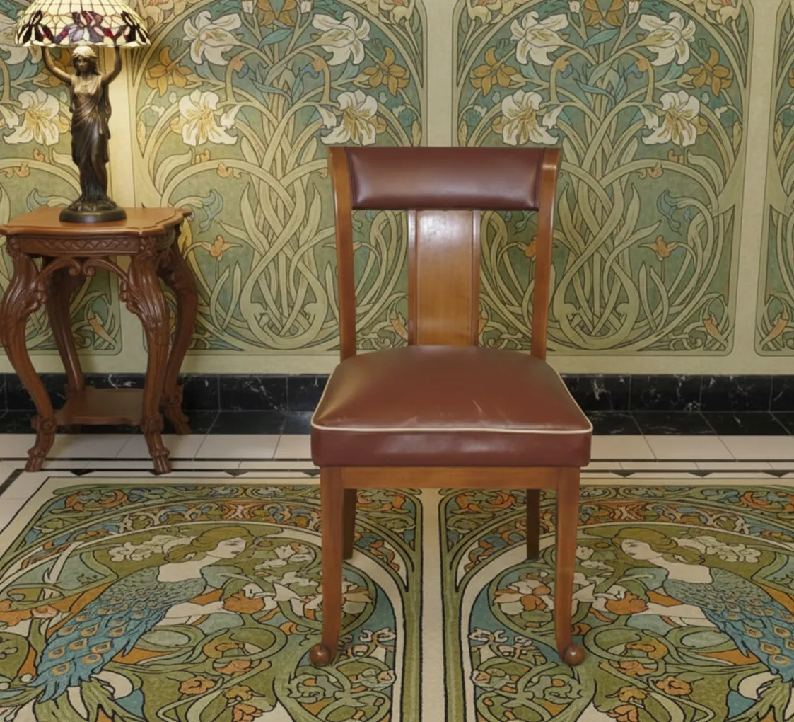 Silla antigua para restaurar en un ambiente decorativo con fondo de flores.