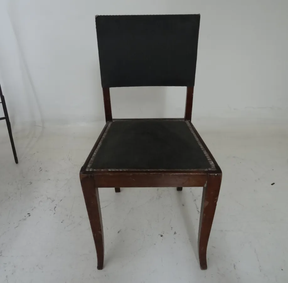 Künstlerischer antiker Stuhl in einem schlichten Umfeld, ideal zur Restauration.