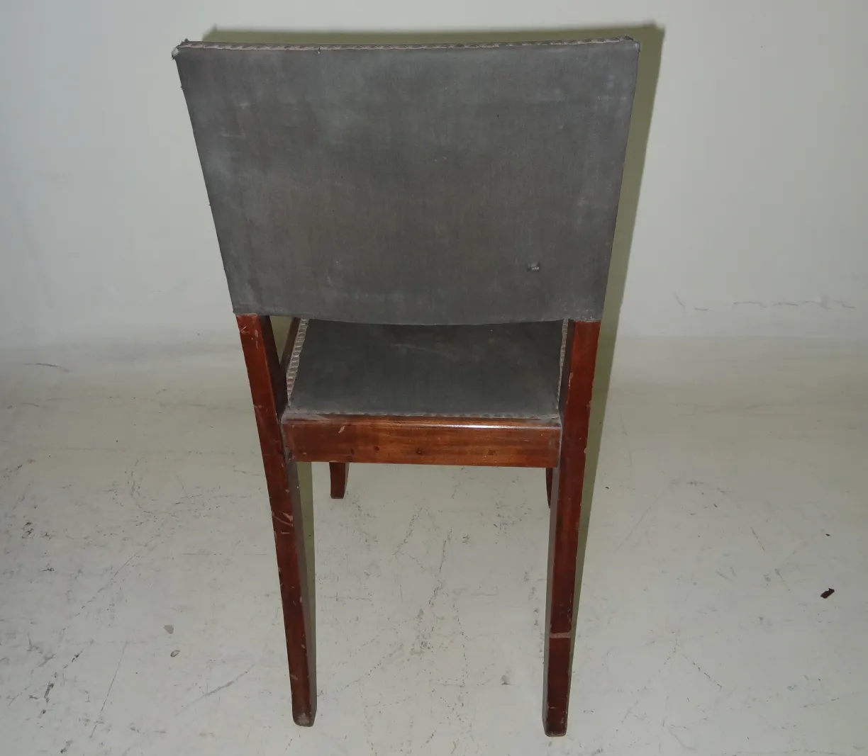 كرسي قديم فن الديكو مع ظهر مرتفع وأرجل خشبية، منظر خلفي.