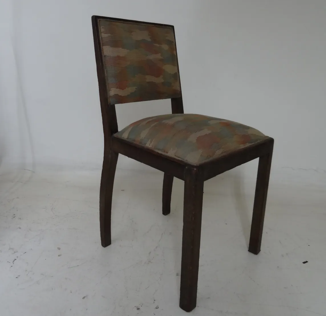 antique chair with colorful upholstery in a neutral setting