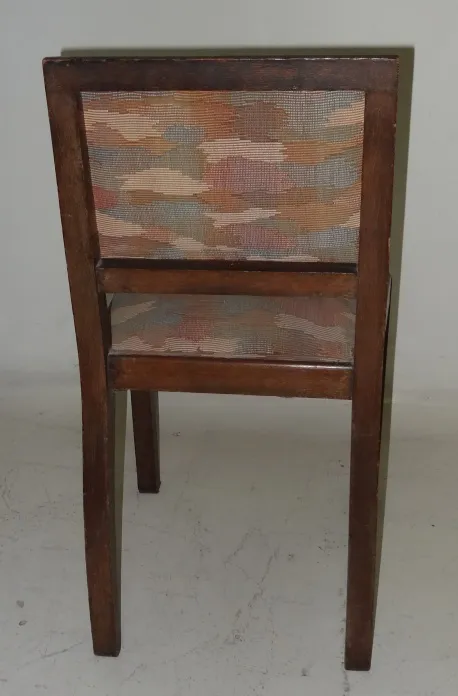 Silla antigua vista desde atrás con tapiz decorativo