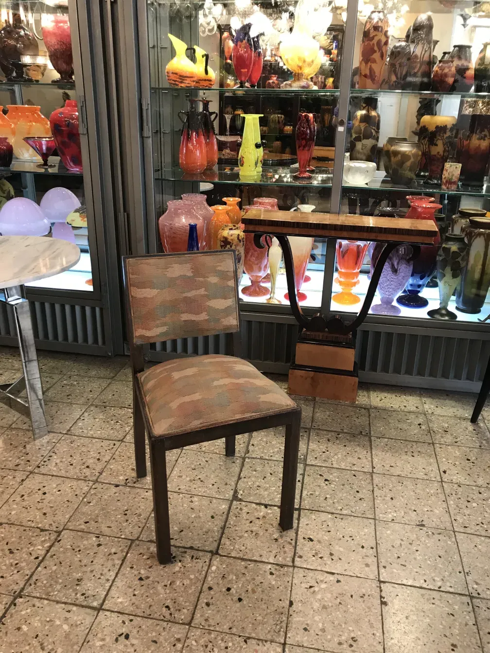 dos sillas antiguas en un ambiente lleno de jarrones coloridos