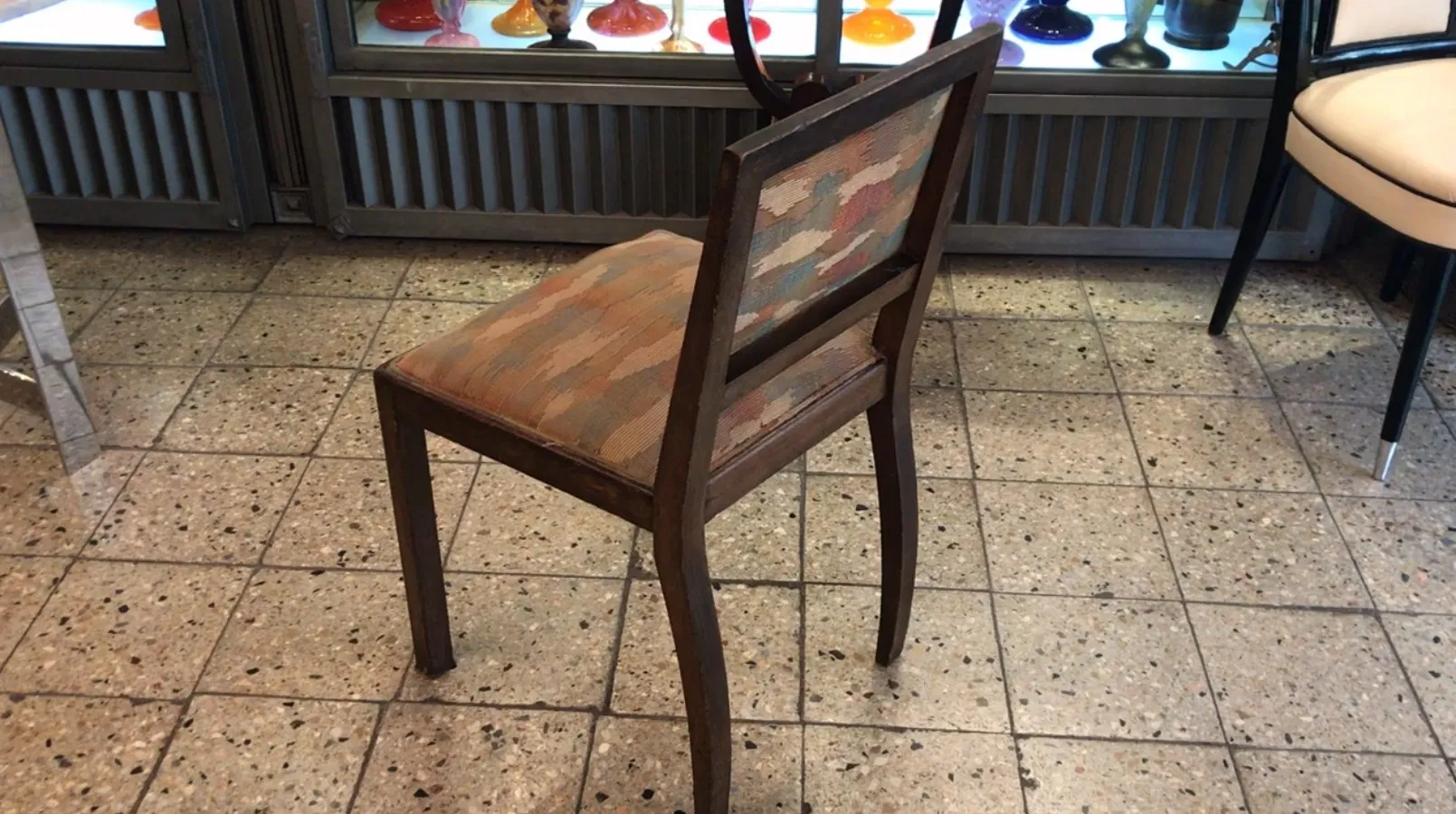 Antique chair with a decorated backrest in a colorful environment.