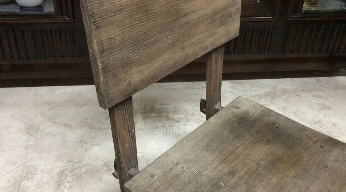 Silla antigua de Jean Michel Frank con un diseño rústico en un ambiente acogedor.