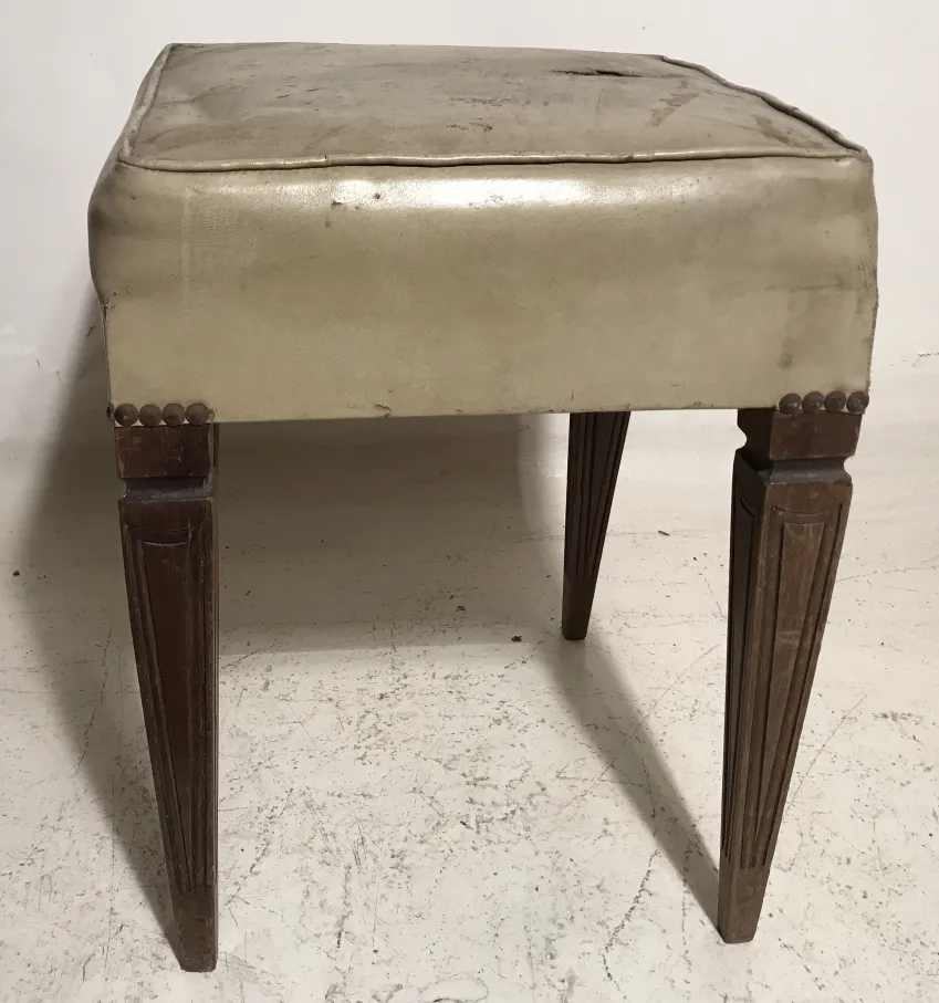 antiker Hocker mit gepolsterter Sitzfläche und verzierten Holzbeinen