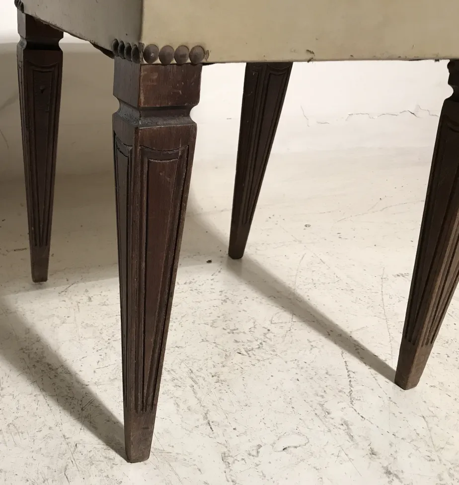 vue d'un ancien tabouret avec pieds sculptés sur un fond clair